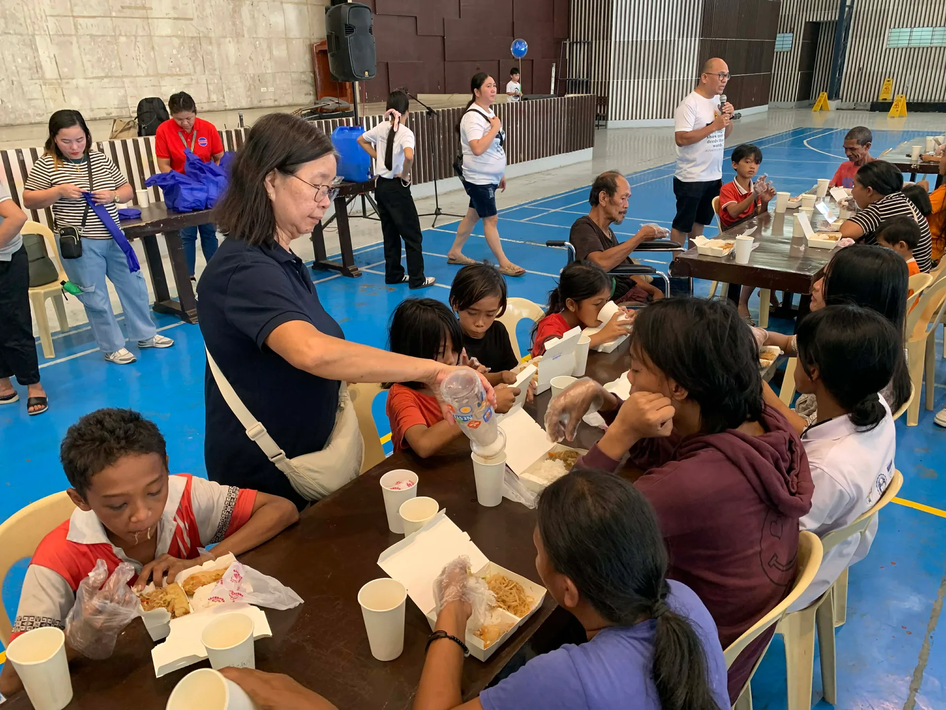 Volunteer serving food to children during community feeding program