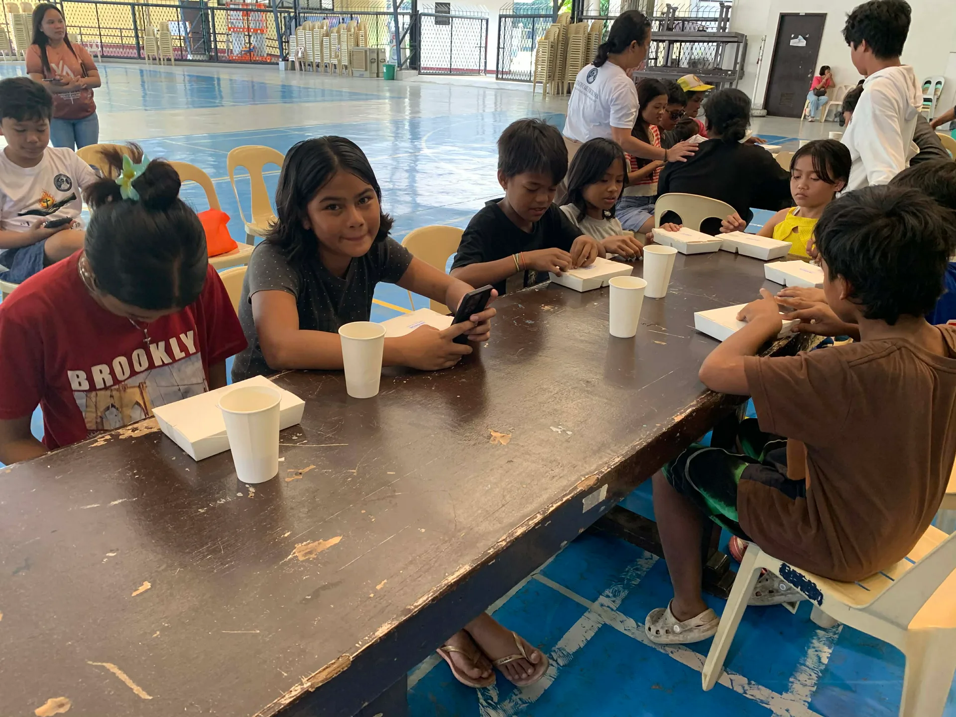 Young girl smiling at the camera during community feeding program