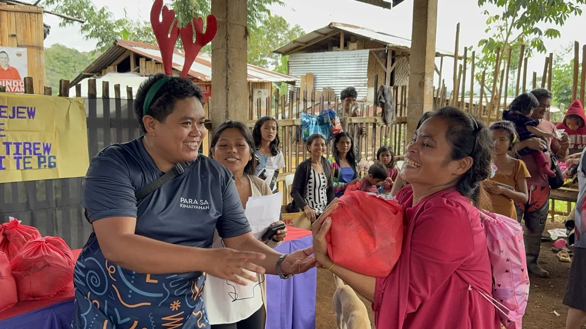 Foundation volunteer handing relief goods to community member