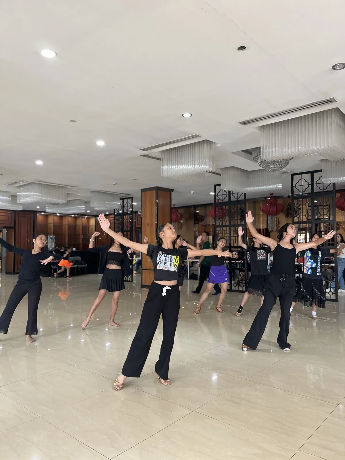 Young DanceSport dancers with arms outstretched in dramatic pose