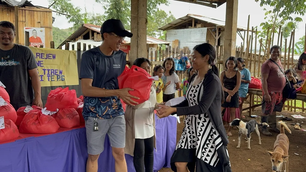 Volunteer handing relief goods to a community member in Bukidnon